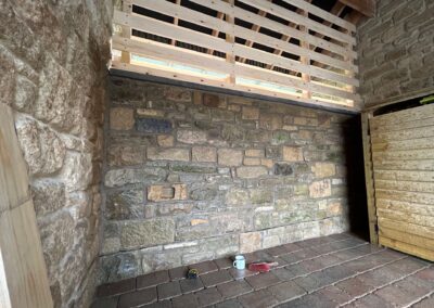 Traditional stone building with a cobbled floor and timber-framed structure.
